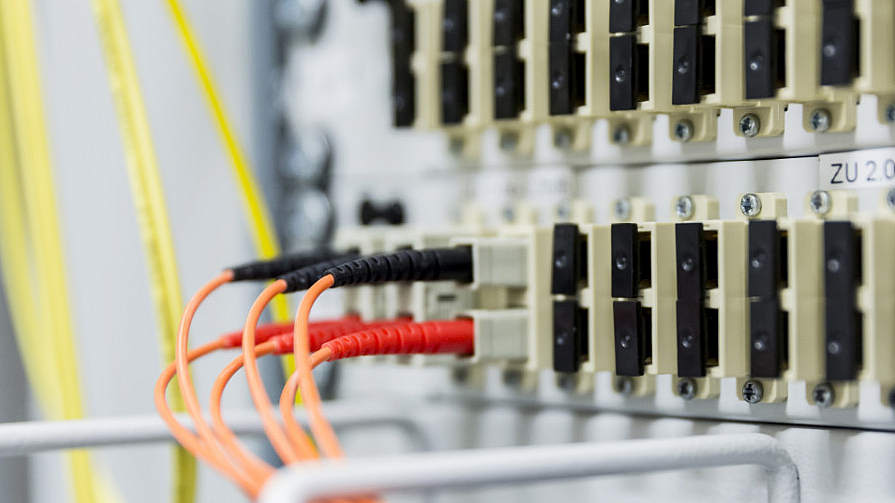 Nahaufnahme eines Servers mit mehreren eingesteckten Kabeln in verschiedenen Farben. 