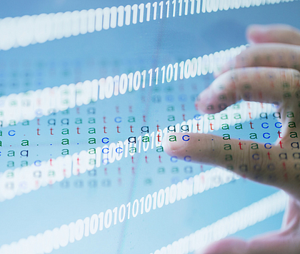 Eine Hand berührt eine digitale Anzeige mit DNA-Sequenzen und binären Zahlen, die auf einem Bildschirm erscheinen.