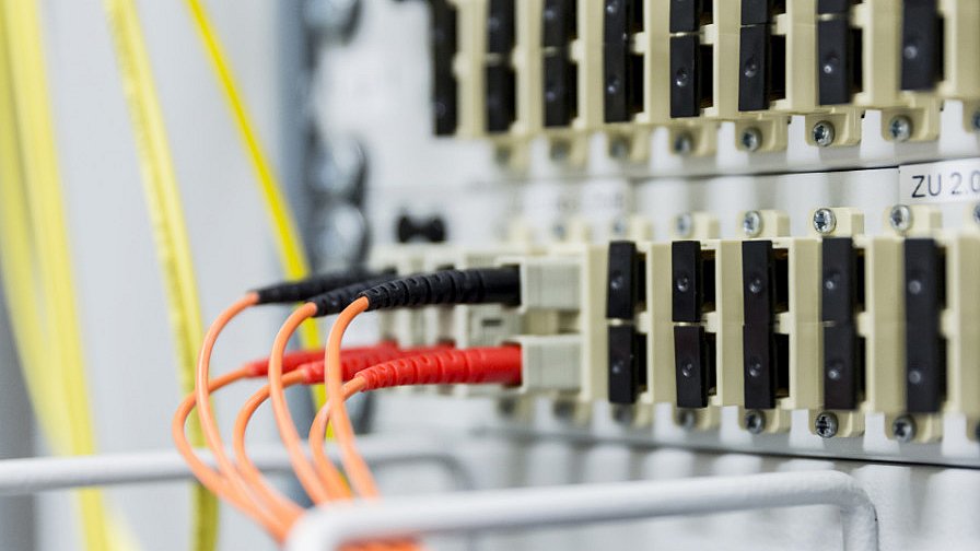 Nahaufnahme eines Servers mit mehreren eingesteckten Kabeln in verschiedenen Farben. 